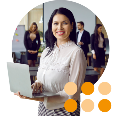 Image of a business person stood in a training room with a laptop