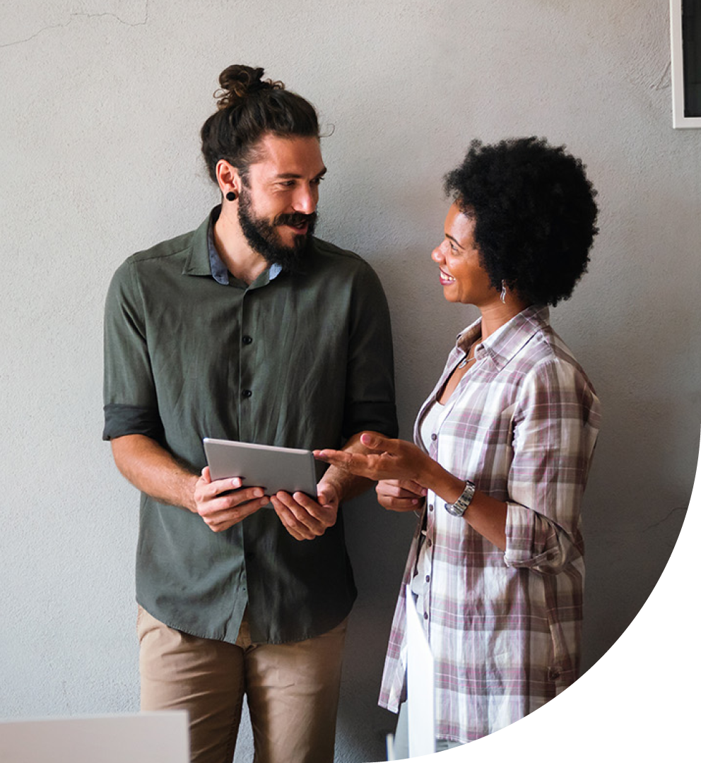 Image of a two people stood up talking with a tablet in their hands