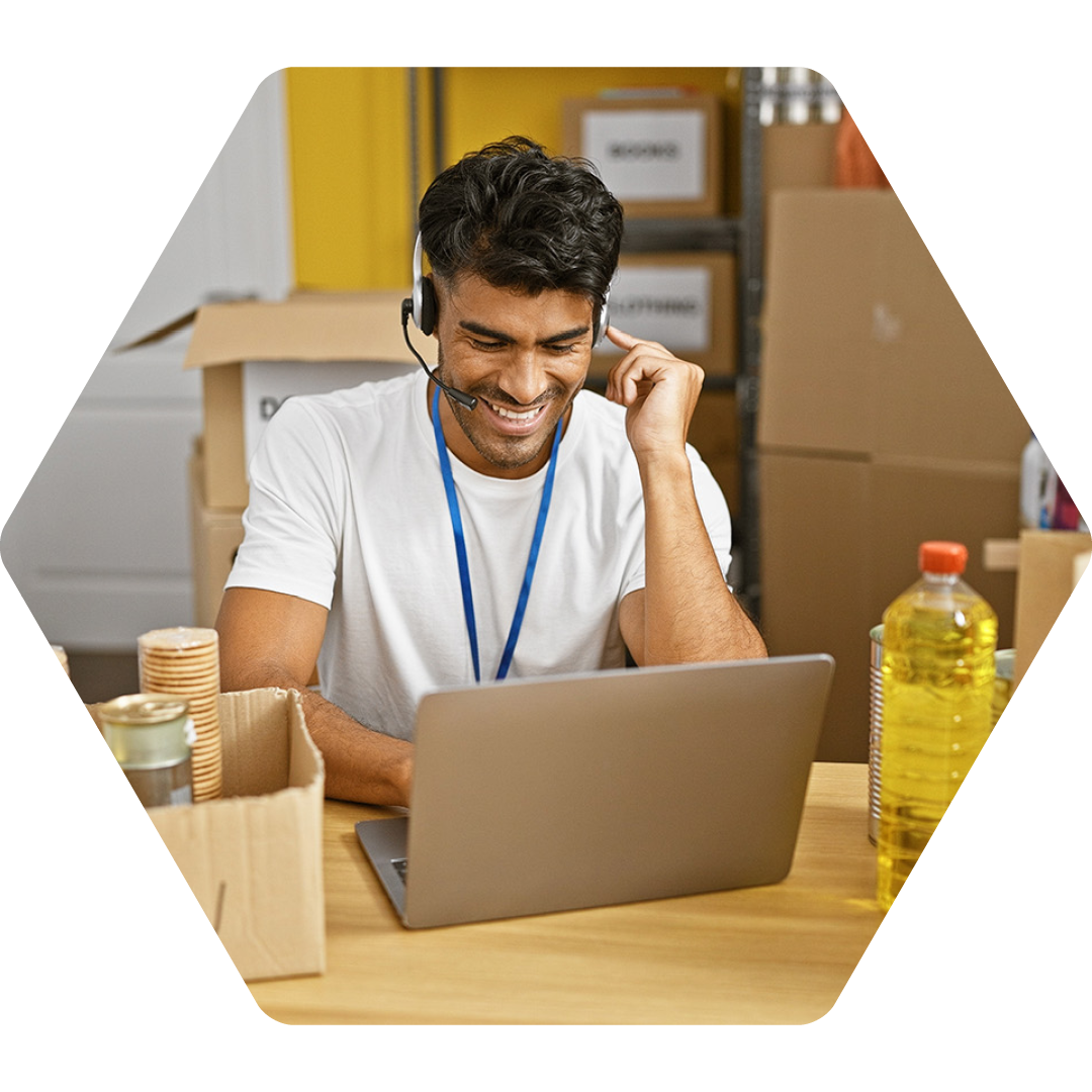 Image of a charity worker talking on a headset and working on a laptop