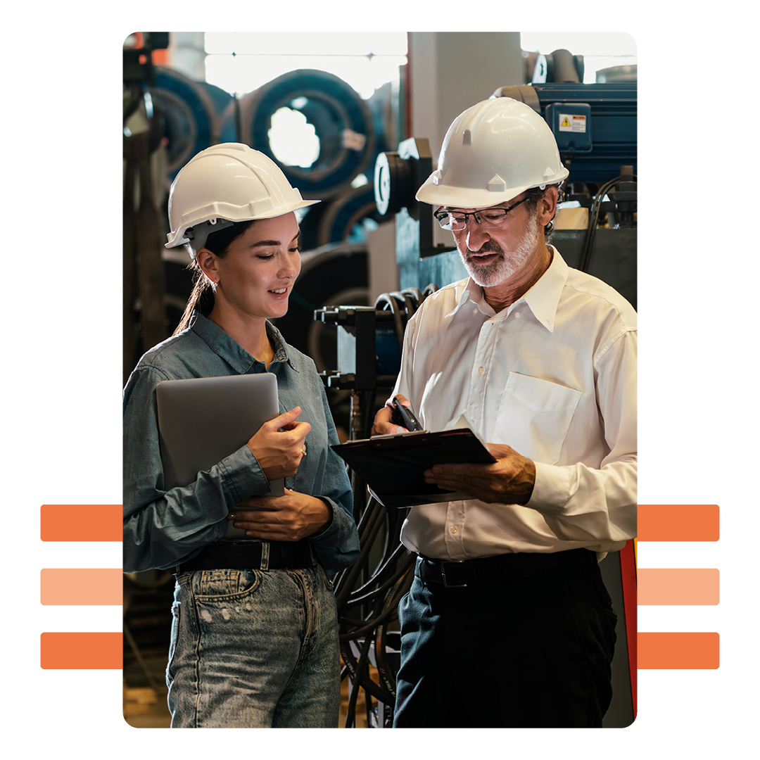 Image of a two manufacturing workers talking over a tablet