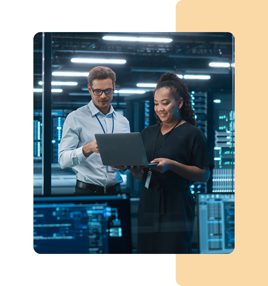 Image of two IT professionals stood in a server room with a laptop