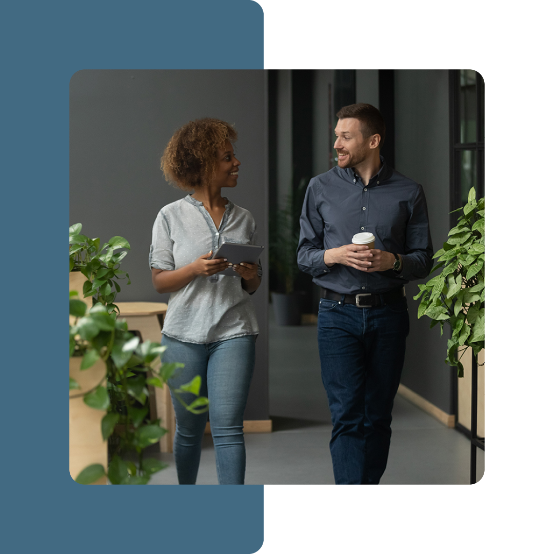 Image of two colleagues walking through an office together