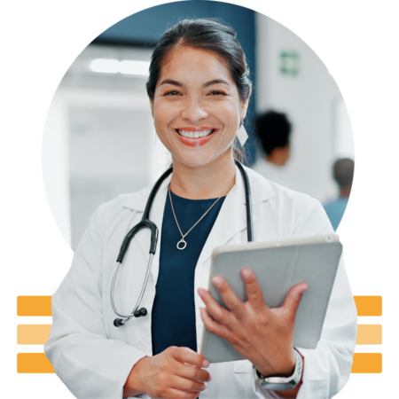 Image of a smiling doctor holding a tablet in a hospital