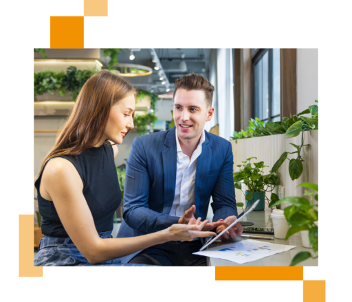 Image of two business professionals sat in an office working on a tablet