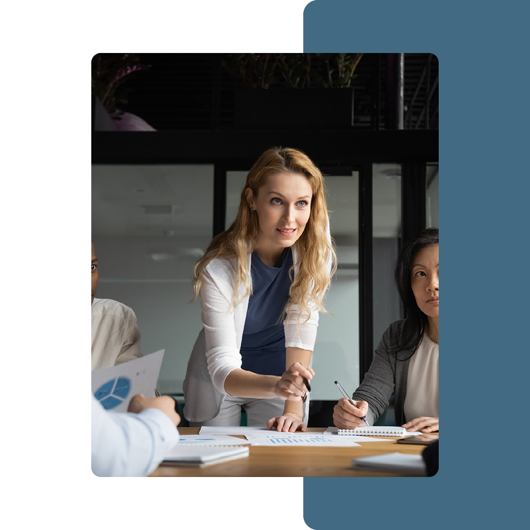 Image of a business person talking to a group of people in a meeting