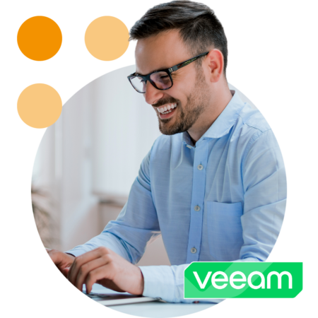 Image of a smiling business professional working on a laptop with the Veeam logo