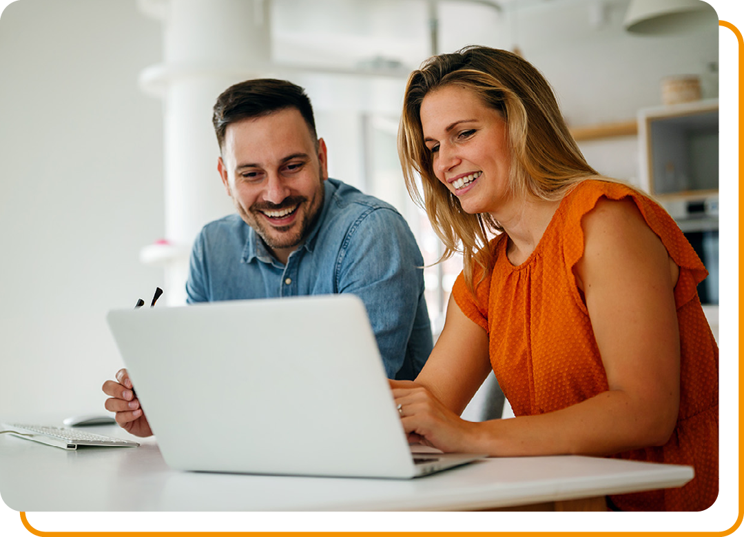 Image of two smiling colleagues working together on a laptop