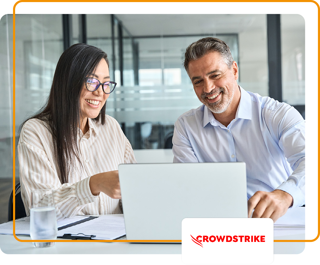 Image of two colleagues working on a laptop together with the Crowdstrike logo