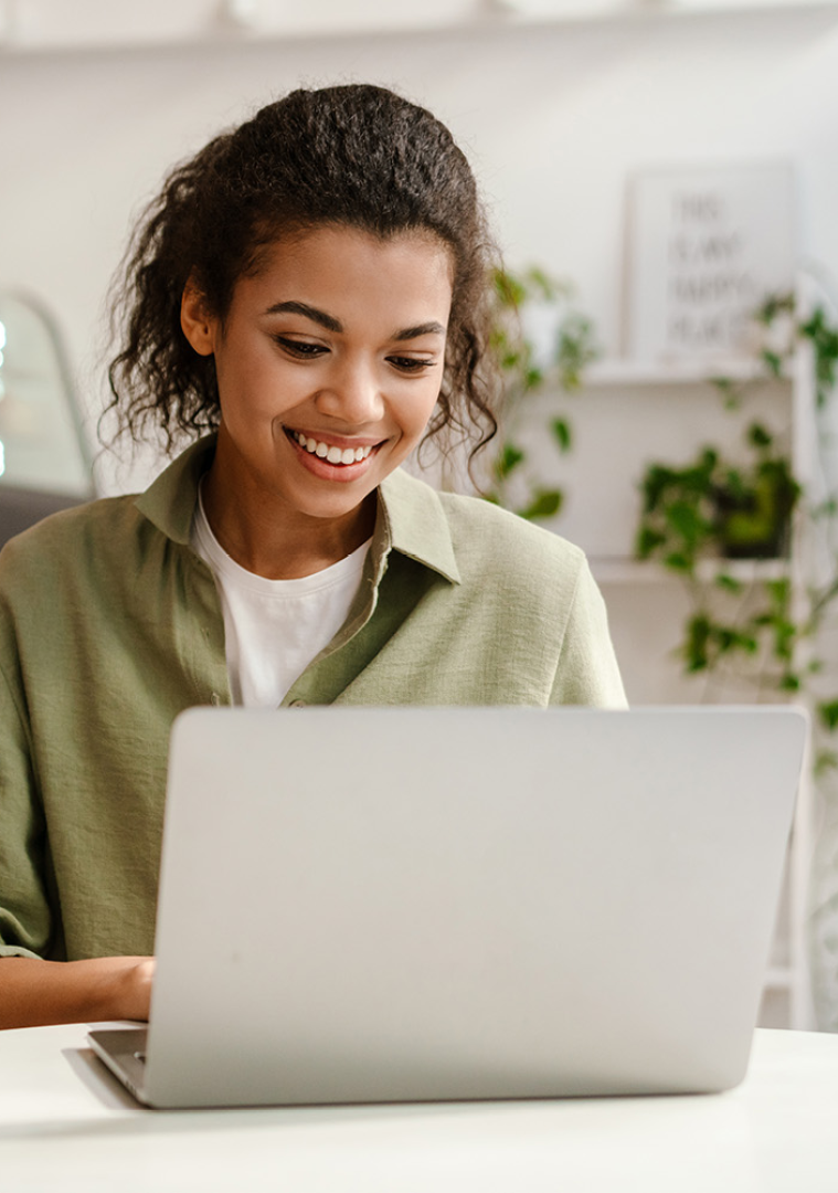 Image of a smiling person working on a laptop