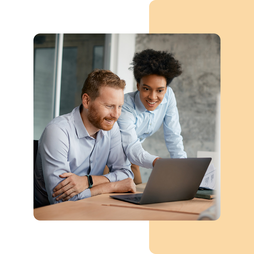 Image of two colleagues working on a laptop together