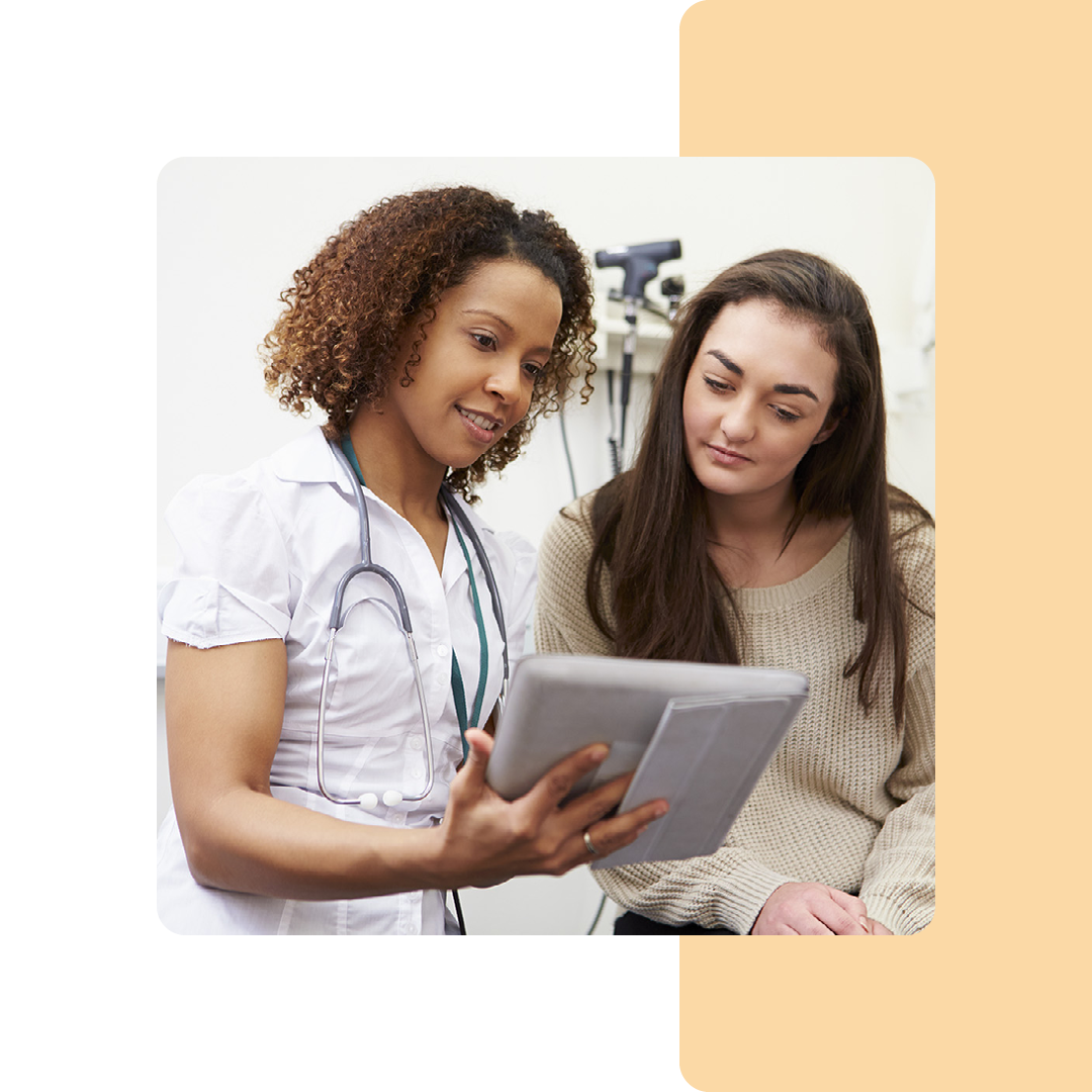 Image of a doctor stood showing a patient information on a tablet