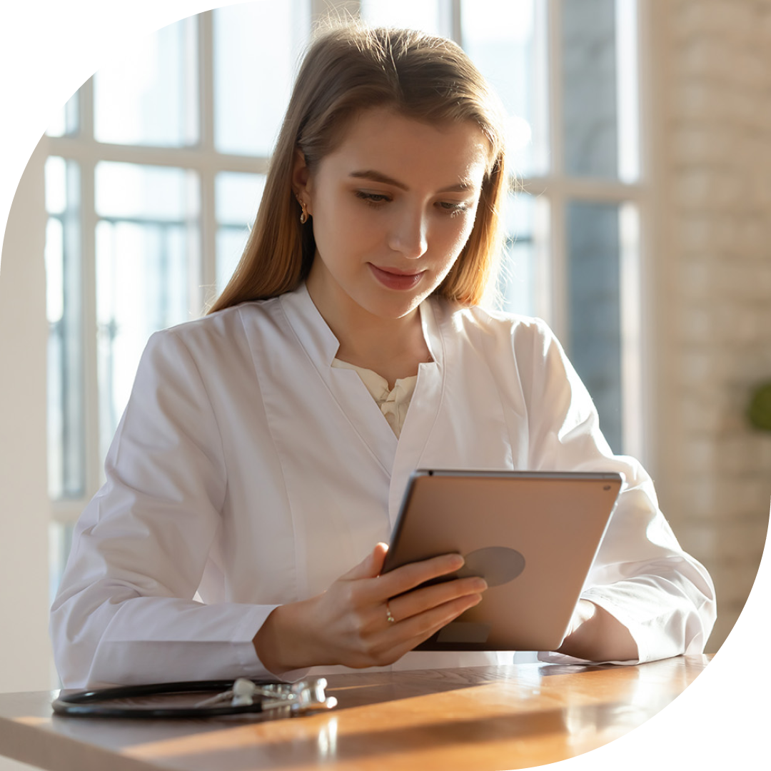 Image of a doctor sat at a desk working on a tablet