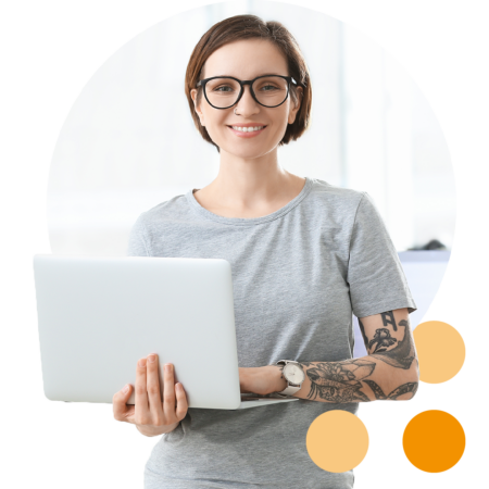 Image of an IT professional stood holding a laptop in an office