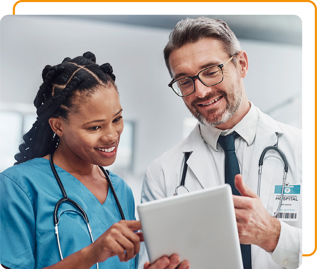 Image of two smiling doctors looking at information on a tablet