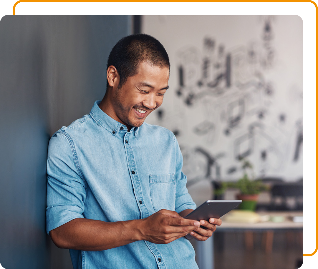 Image of a smiling business professional stood in an office holding a tablet