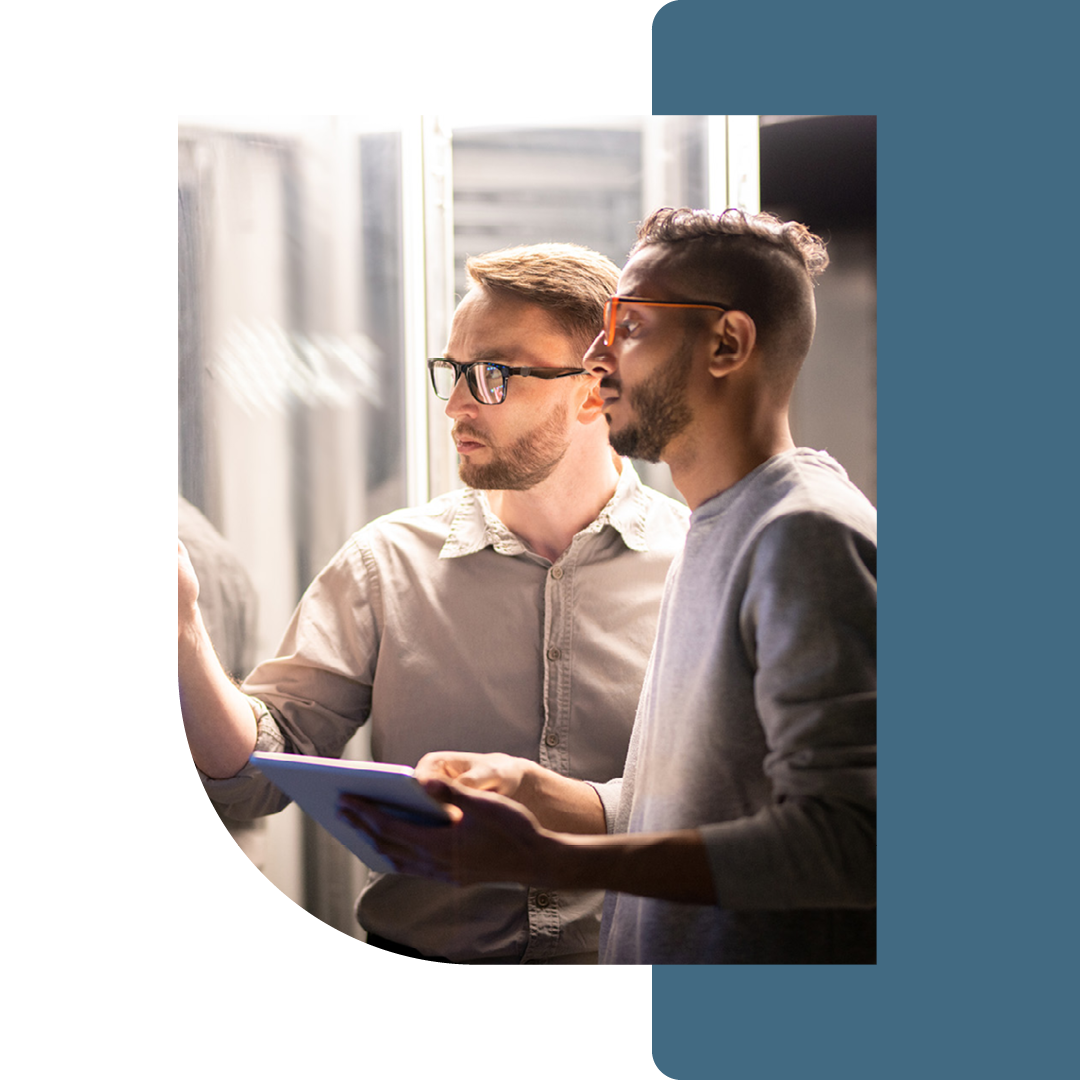 Image of two people working in a server room together