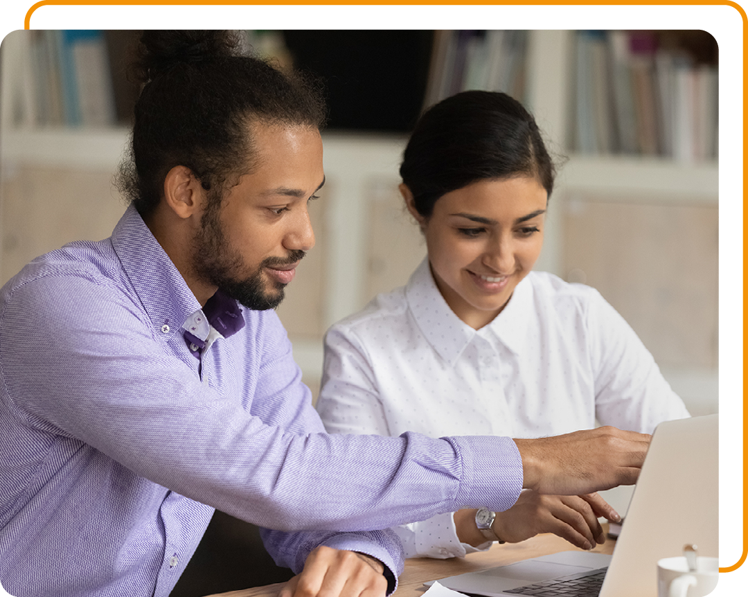 Image of two colleagues working together on a laptop