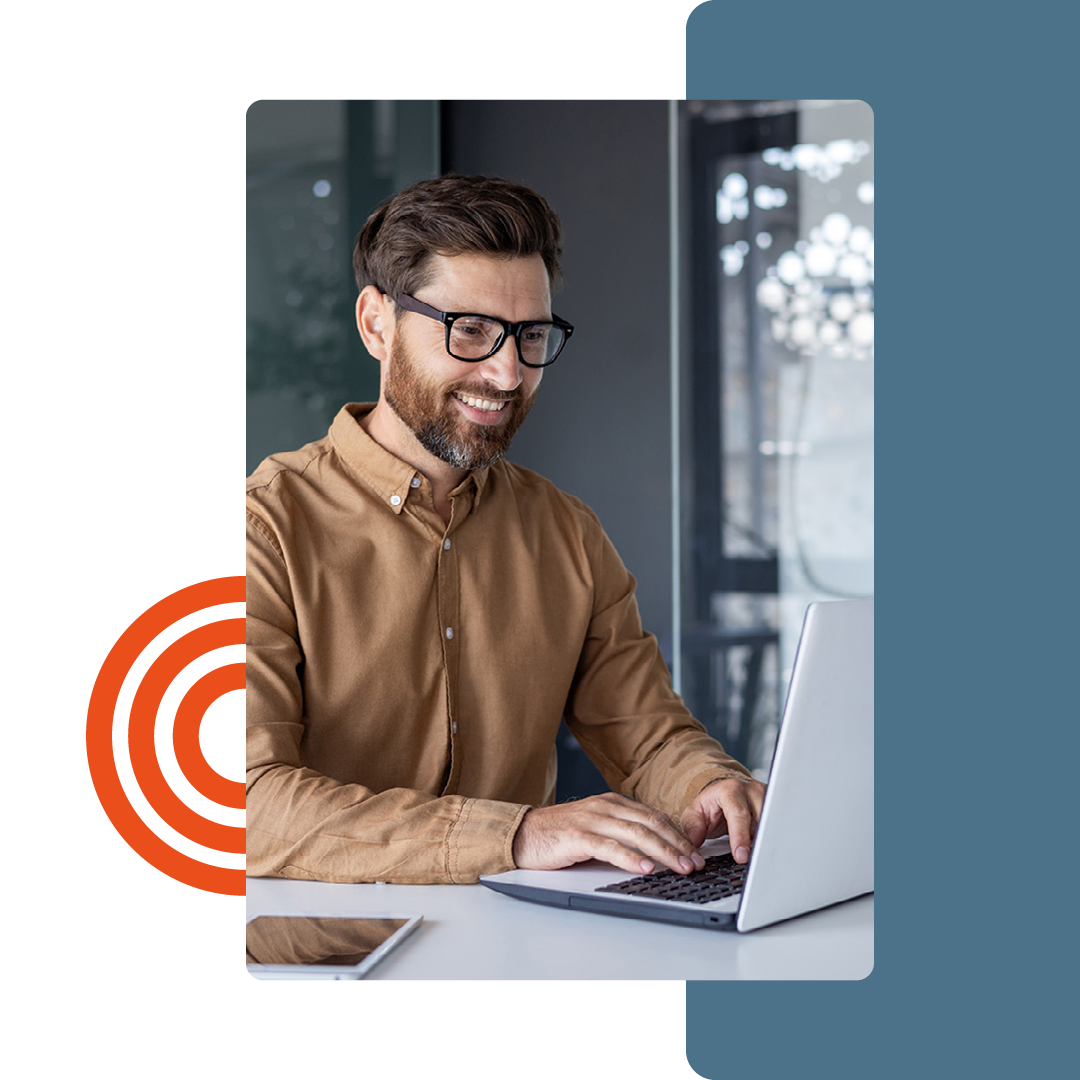 Image of a person smiling while working on a laptop