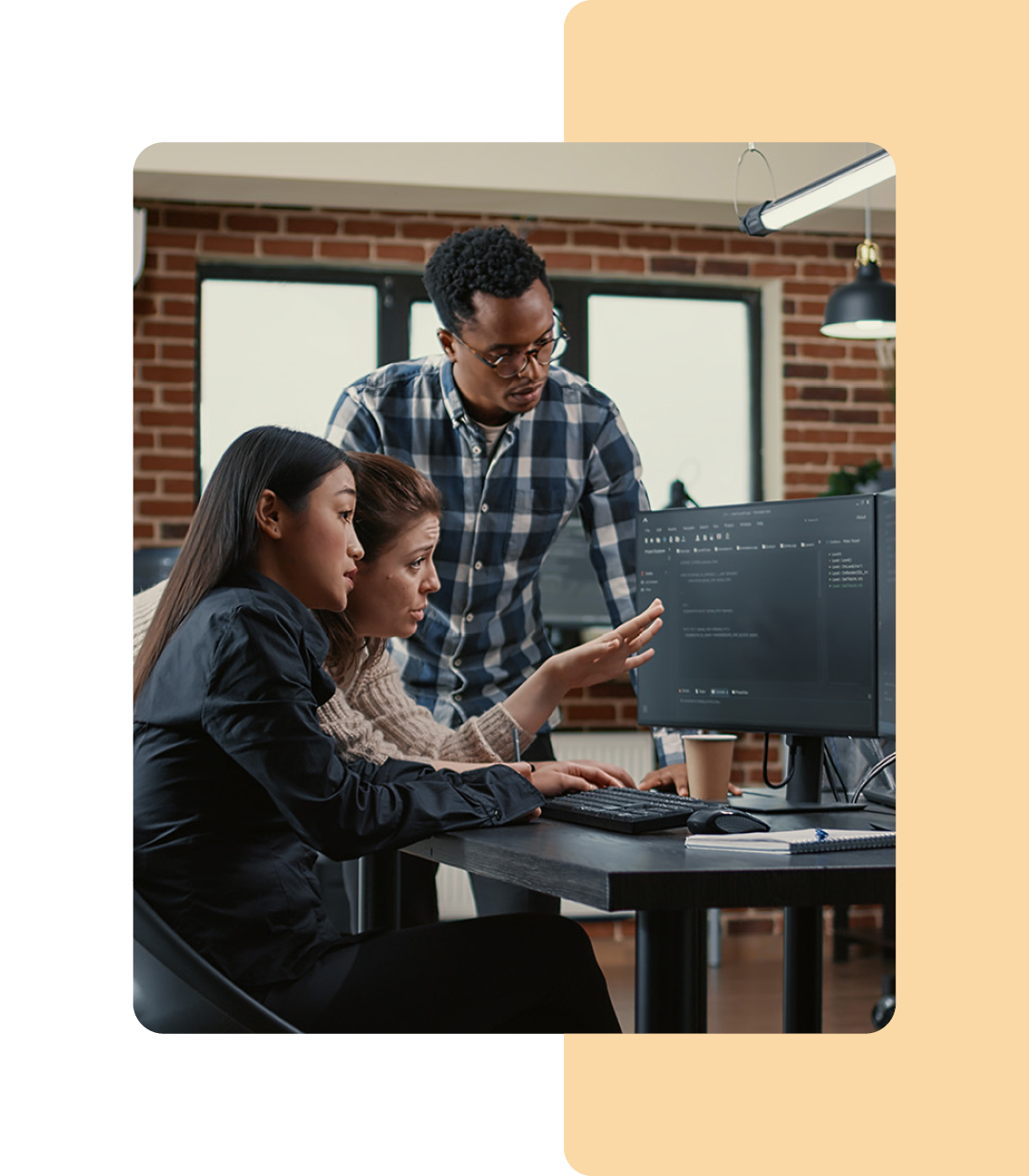 Image of three IT professionals collaborating around a computer