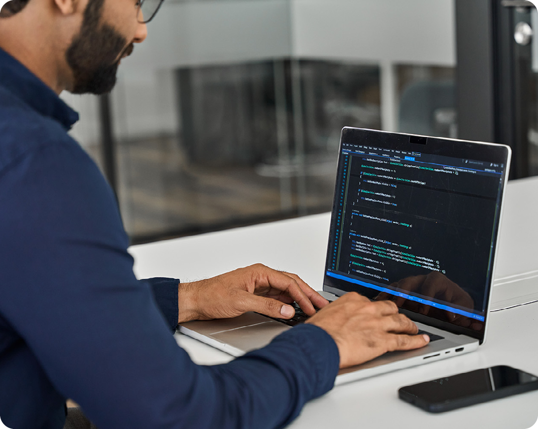 Image of an IT security professional analysing code on a laptop