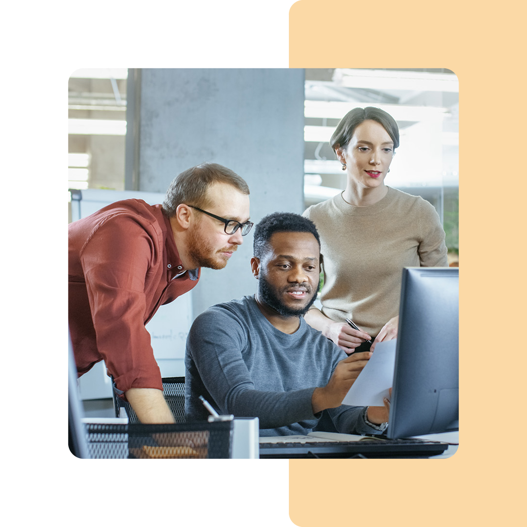 Image of a group of coworkers collaborating around a computer