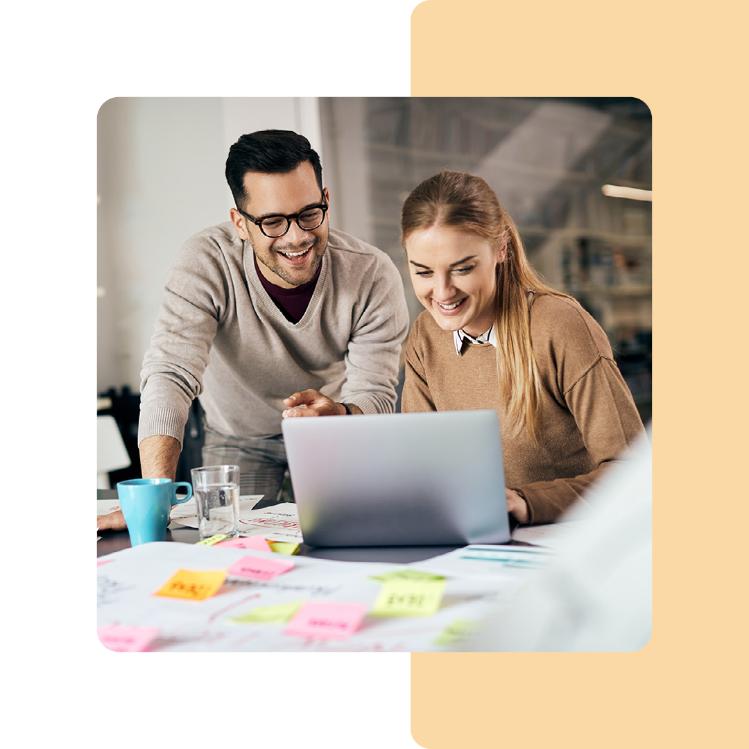 Image of two coworkers collaborating on a laptop