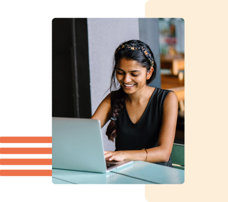 Image of a person smiling while working on a laptop