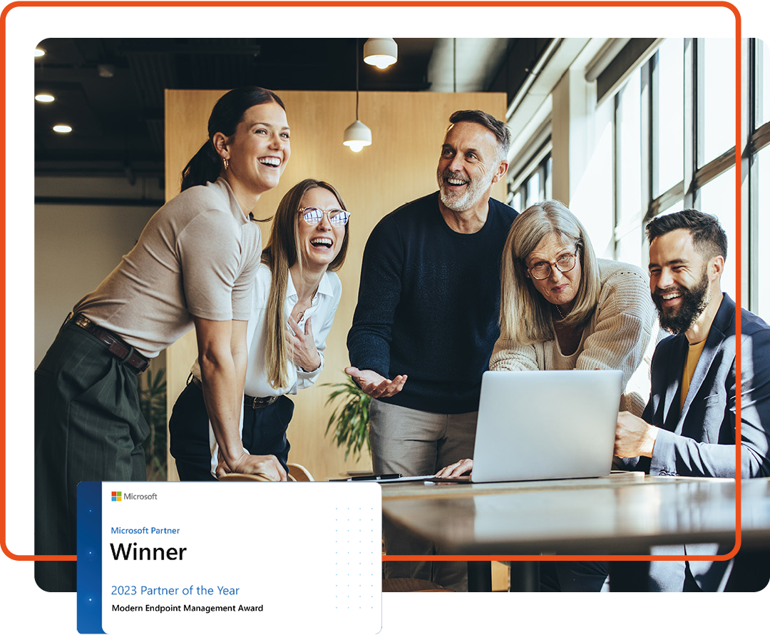 Group of people working together around a desk with the Microsoft Modern Endpoint Management of the Year logo