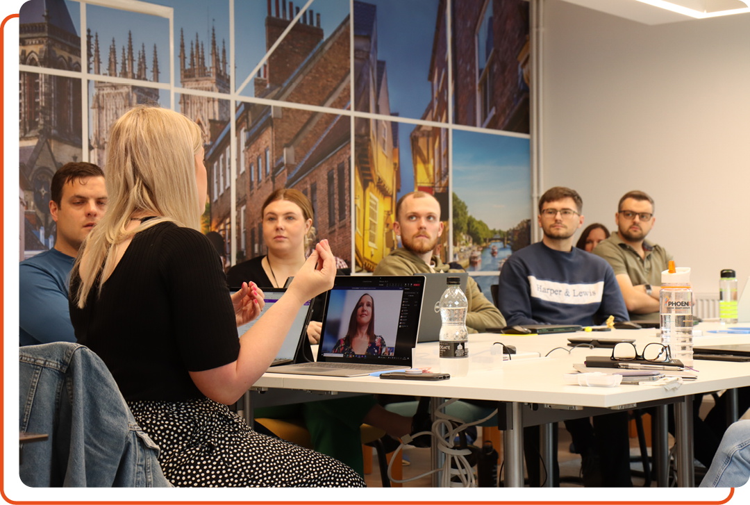 Image of a group of people being trained in a meeting space