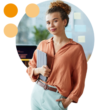 Image of a business person stood holding a tablet in an office