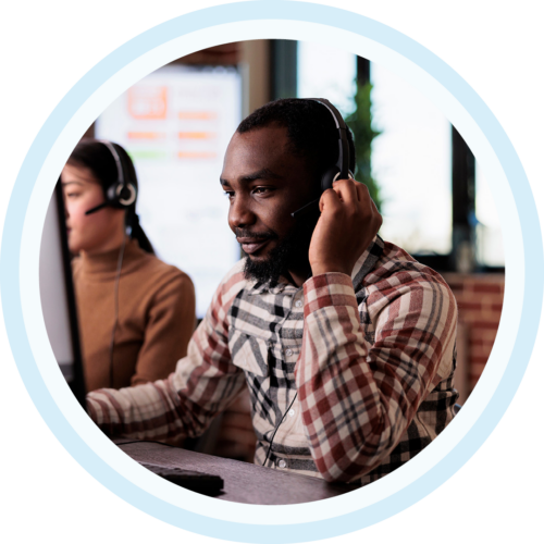 Image of an IT support professional working on a computer with a headset on