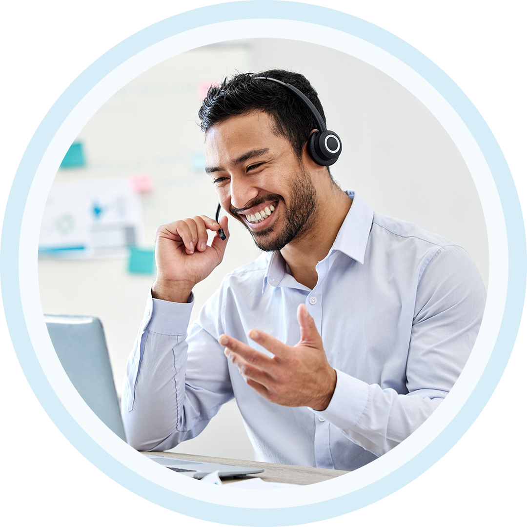 Image of an IT support professional working on a laptop with a headset on