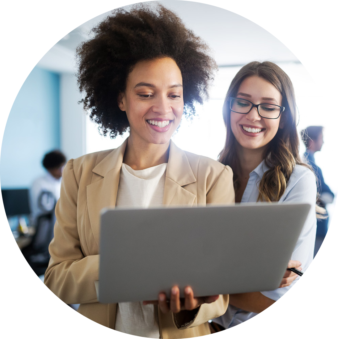 Image of two smiling colleagues working on a laptop