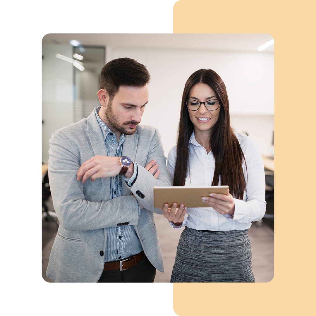 Image of two business colleagues stood working on a tablet