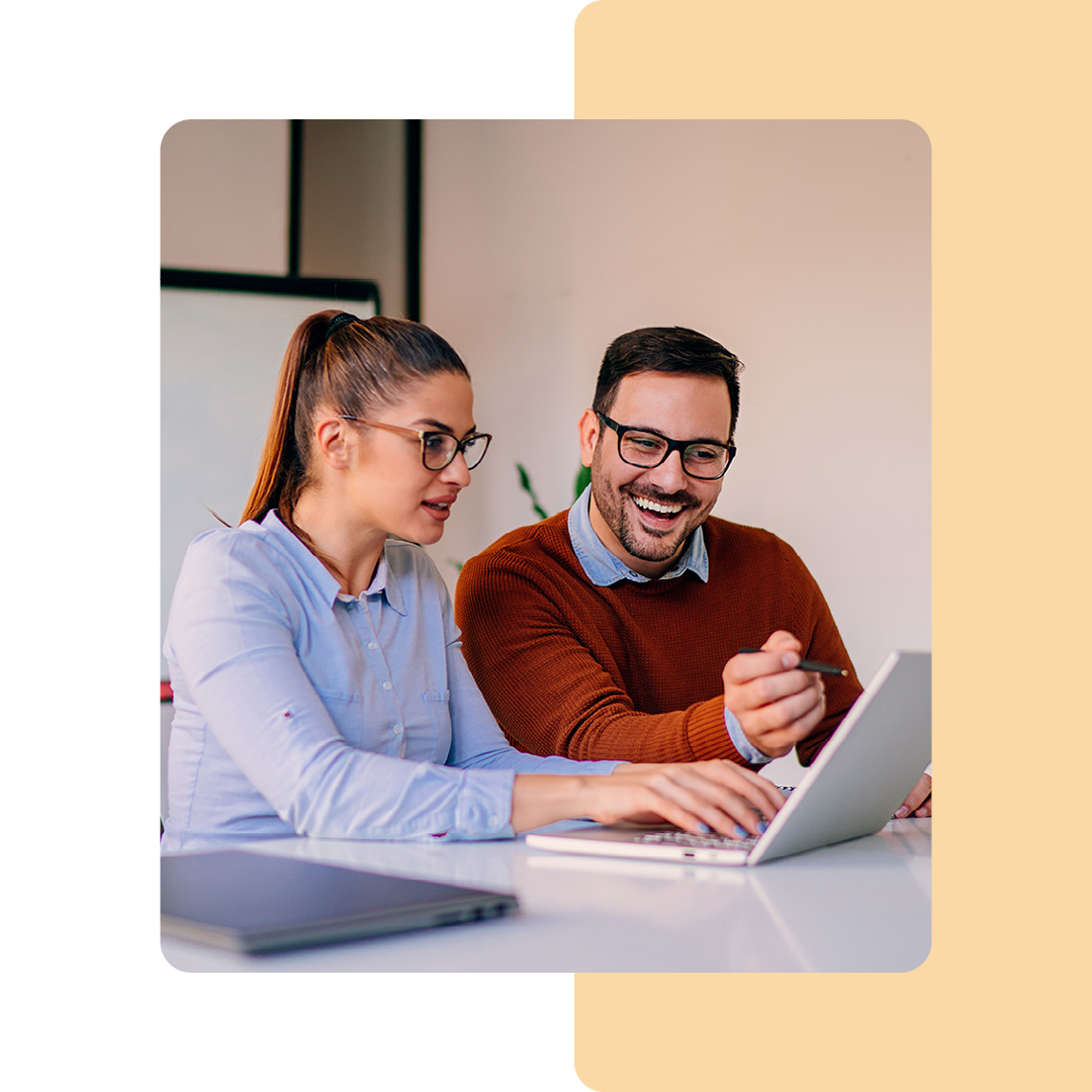 Image of two colleagues working together on a laptop