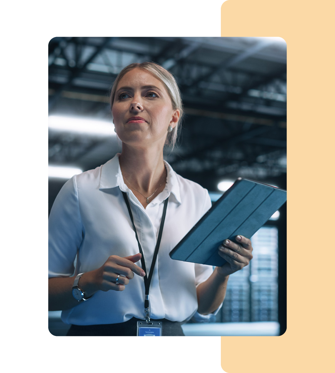 Image of an IT professional walking in a server room holding a tablet