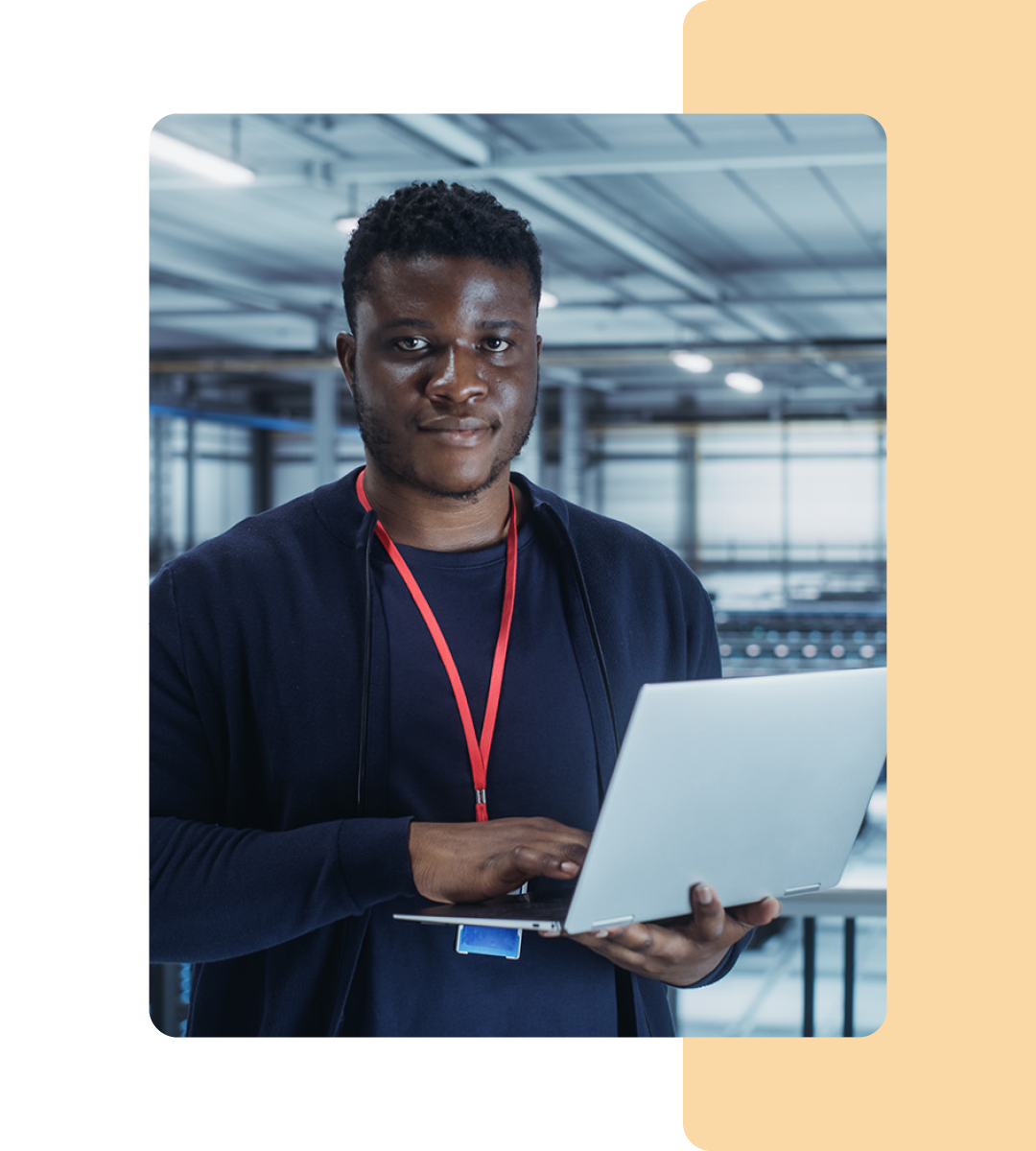 Image of an IT professional walking in a server room holding a laptop