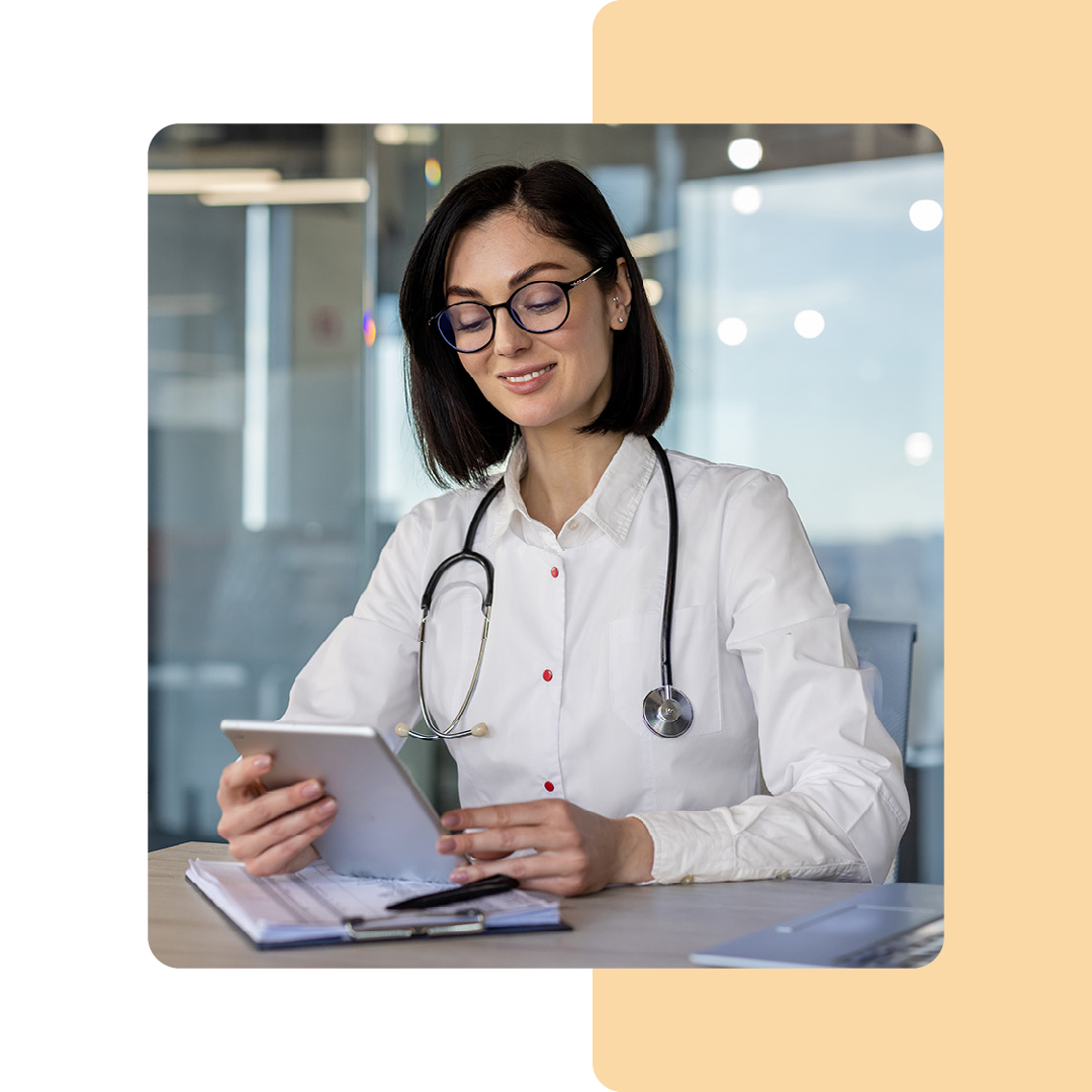 Image of a doctor sat at a desk working on a tablet