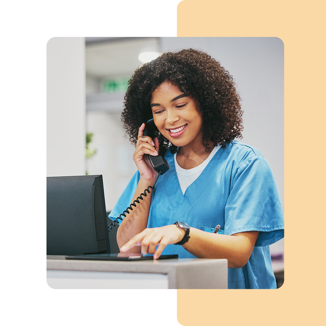 Image of a doctor talking on a phone and working on a tablet