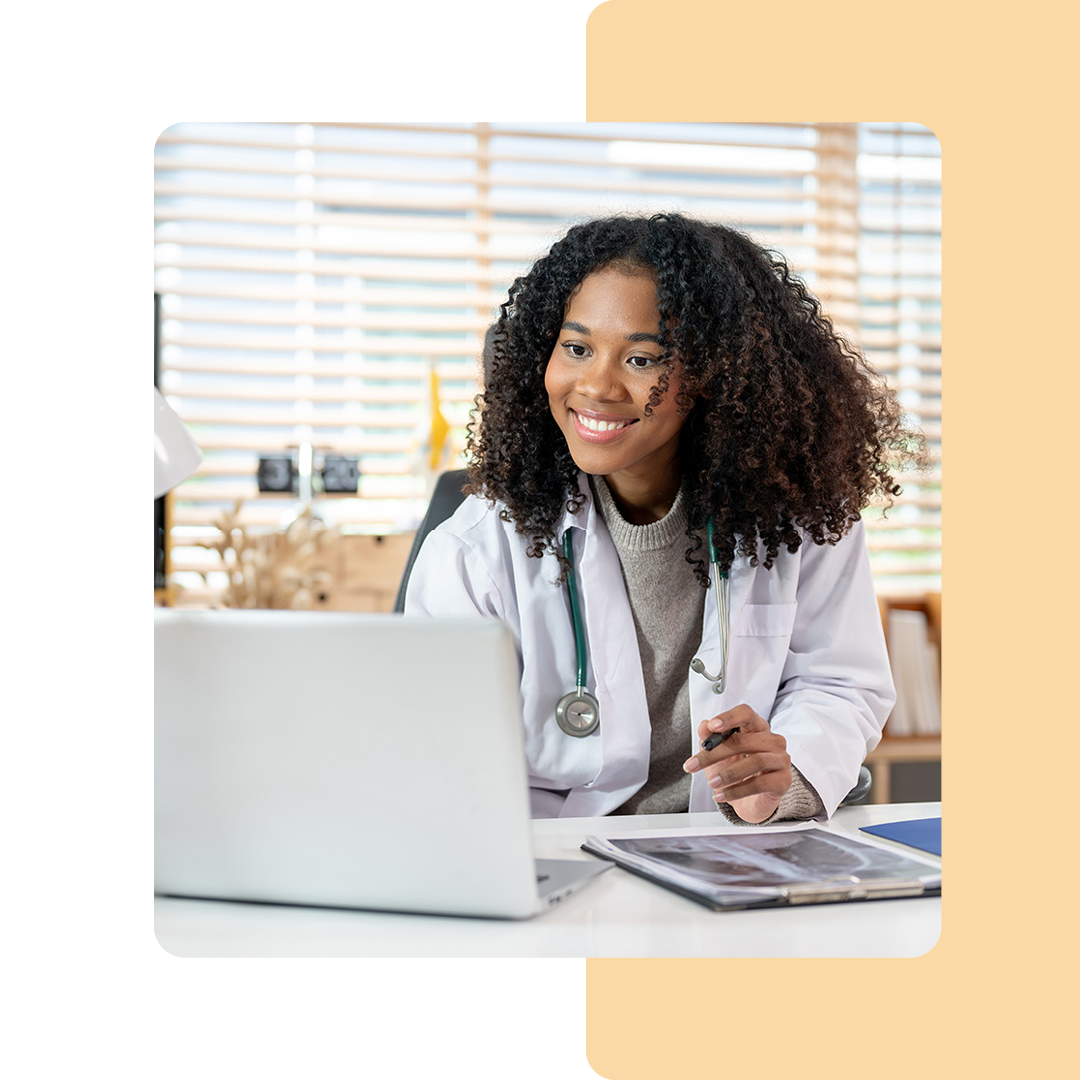 Image of a smiling doctor working on a laptop