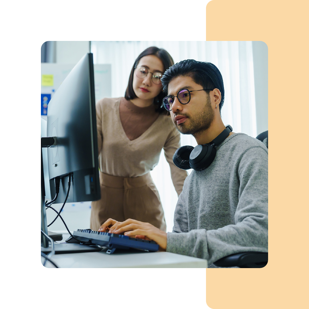 Image of two IT professionals working on a computer together