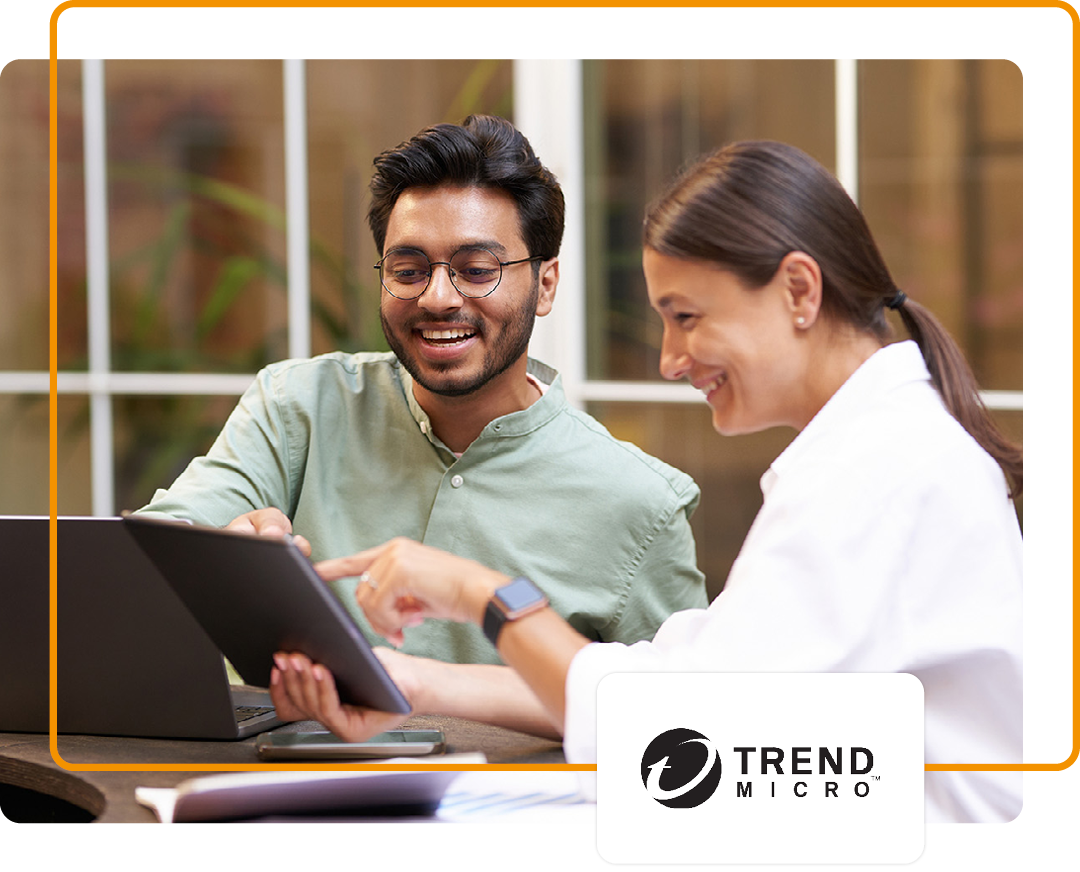 Image of two colleagues conversing while working on a laptop with the Trend Micro logo