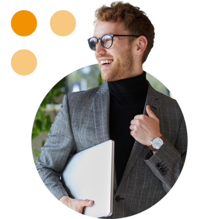 Image of a smiling business professional stood in an office holding a laptop