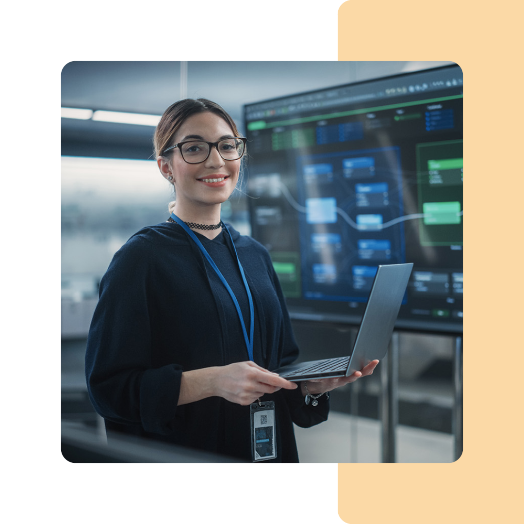 Image of an IT professional stood holding a laptop