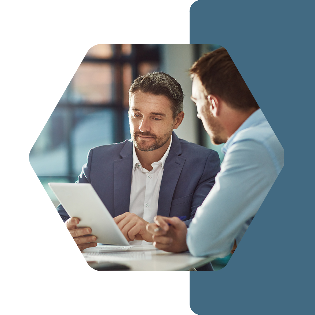 Image of two professionals talking in a meeting and looking at a tablet