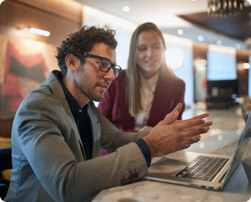 Image of two colleagues working together on a laptop