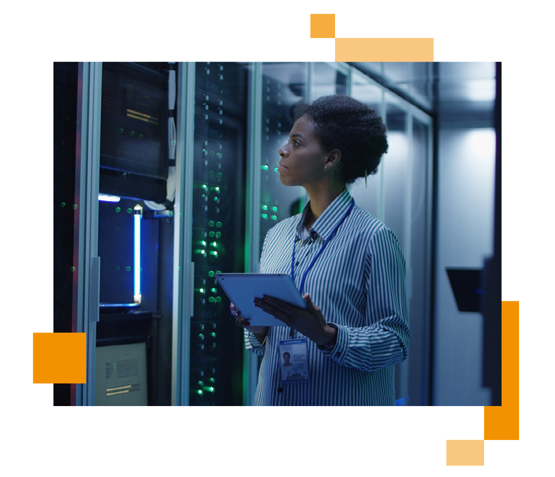 Image of an IT professional stood in a server room holding a tablet