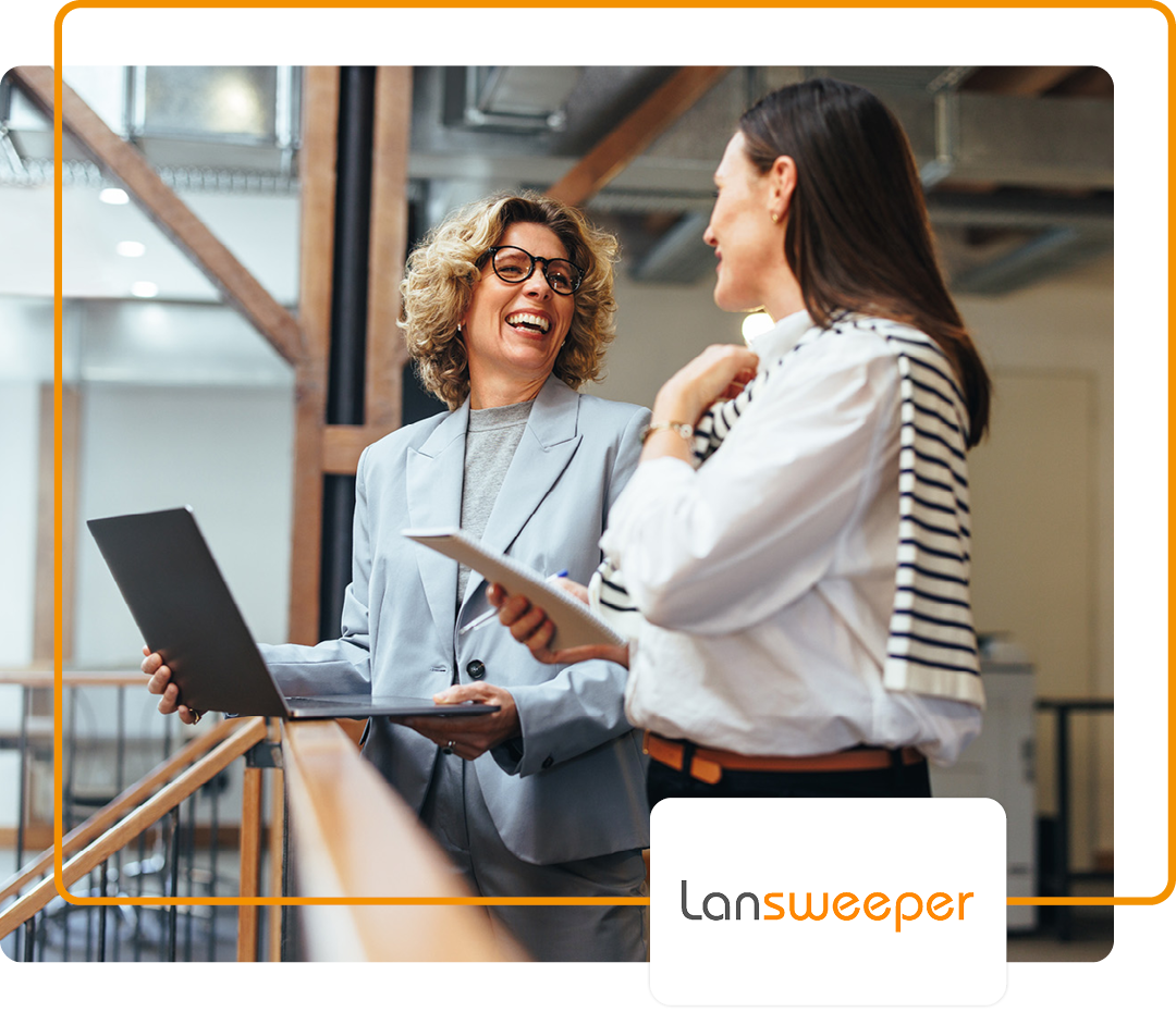 Image of two colleagues in conversation in an office environment with the Lansweeper logo