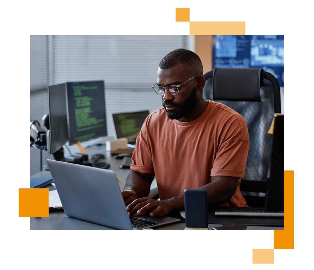 Image of an IT professional working on a laptop at a desk