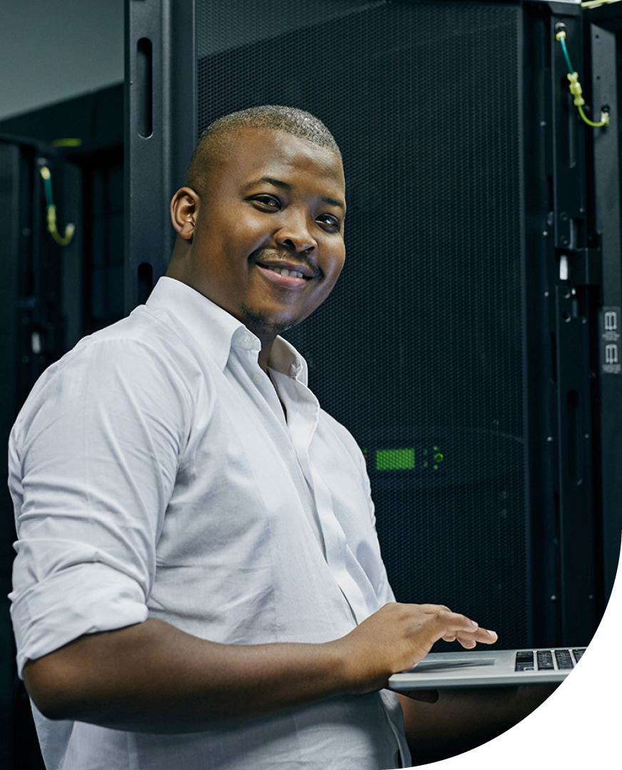 Image of an IT professional working on a laptop in a server room